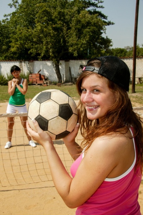 Chicas de aspecto joven tienen sexo lésbico cerca de una cancha de voleibol al aire libre