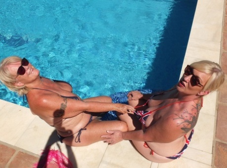 Lesbianas rubias maduras Randy Raz y Melody se acarician las tetas en una piscina