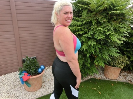 Den buttede blonde dame Barby er nøgen, mens hun træner i sin baghave