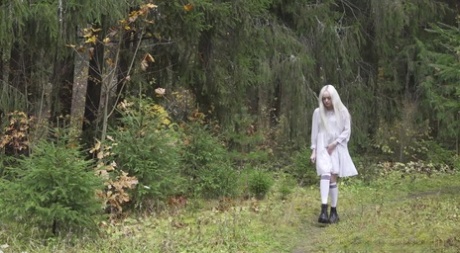 Platinblondes Mädchen Eva pisst während eines Spaziergangs in der Nähe des Waldes