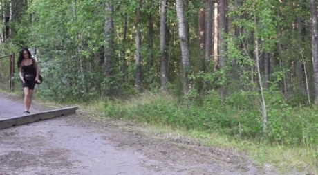 La ragazza dai capelli scuri Gypsy Queen fa una pipì urgente contro un albero sul ciglio della strada