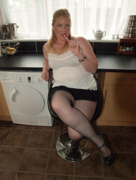 Die dicke Amateurin Samantha zieht ihre Netzstrumpfhose in einer Küche herunter