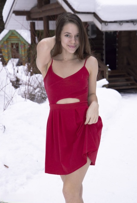 La joven morena Flamy Nika revela su cuerpo caliente en el suelo cubierto de nieve