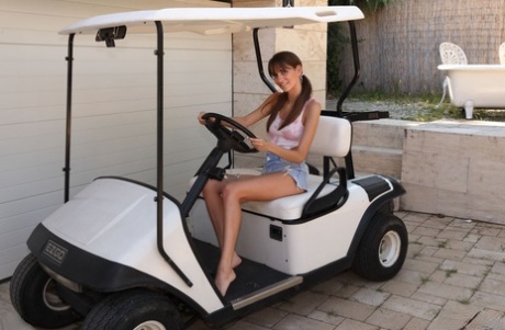 La giovane Lili Charmelle ha dei morsetti attaccati alla sua figa nuda su un golf cart