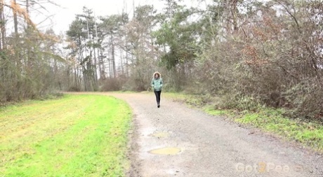 Ali Bordeaux wird beim Pinkeln in eine Pfütze auf einem Feldweg erwischt