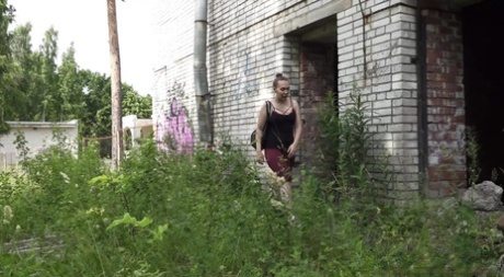 La chica sola Diana Sweet mea en la entrada de un edificio abandonado