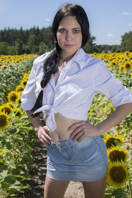 Sonja, une adolescente aux cheveux noirs, se déshabille dans un champ de tournesols.