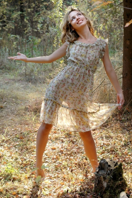 Unga blonda Natalia B tar av sig klänningen för att gå helt naken i skogen