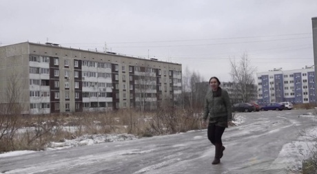 Anya, una chica bajita, se agacha detrás de un edificio para mear.