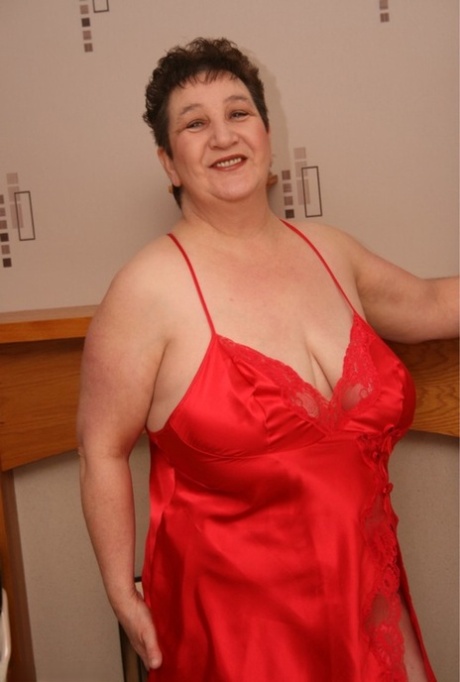 Zralá žena s nadváhou Kinky Carol uvolňuje svá velká prsa z červeného spodního prádla