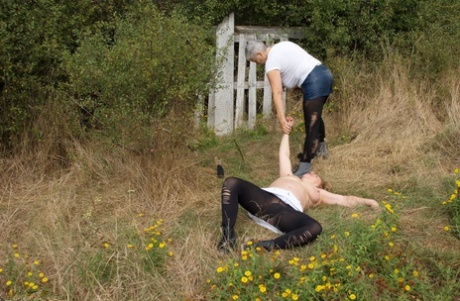 Old British woman restrains busty mature lady Speedy Bee while in the outdoors