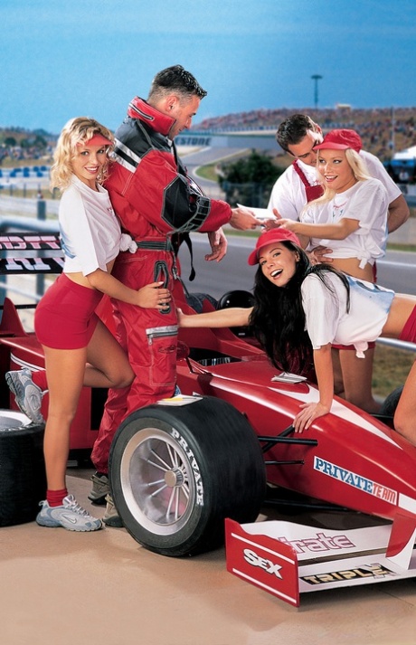 Hot chicks engage in group sex over top of a Formula One car