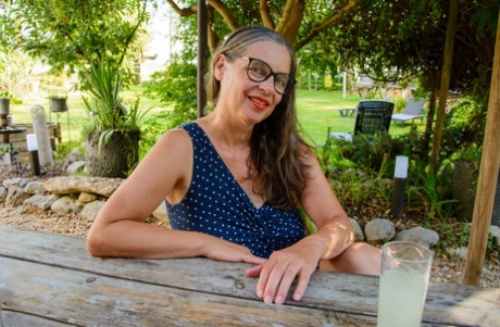 Older lady Busty Tina sits her large tits and bush free on a picnic table