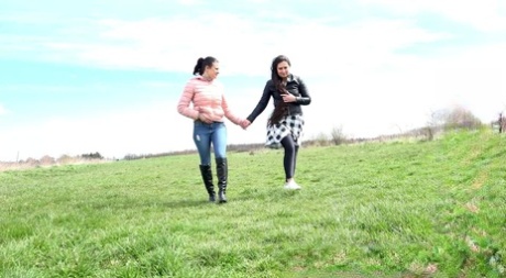 Billie and Lara Fox walk hand-in-hand after pissing in a wide-open field