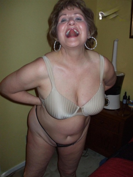 Reife Frau Busty Bliss entblößt ihre natürlichen Titten, während sie einen schwarzen Tanga trägt
