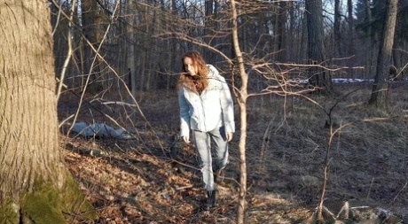 Nikky B, una ragazza caucasica, si appoggia a un albero mentre fa pipì