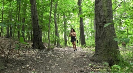 La ragazza dai capelli scuri Maddi Black piscia mentre cammina nel bosco