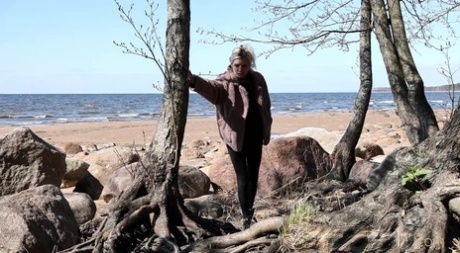 Ragazza bionda Vasya si appoggia indietro contro un albero mentre l