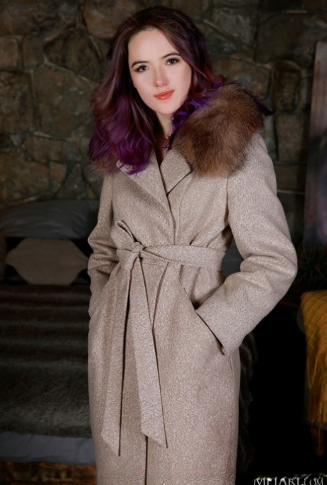 La bella teenager Sofi Roko si toglie il cappotto mentre si spoglia in calze di nylon bianche
