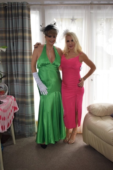 Mature lesbians Emerald and Dimonty partake in foreplay while dolled up