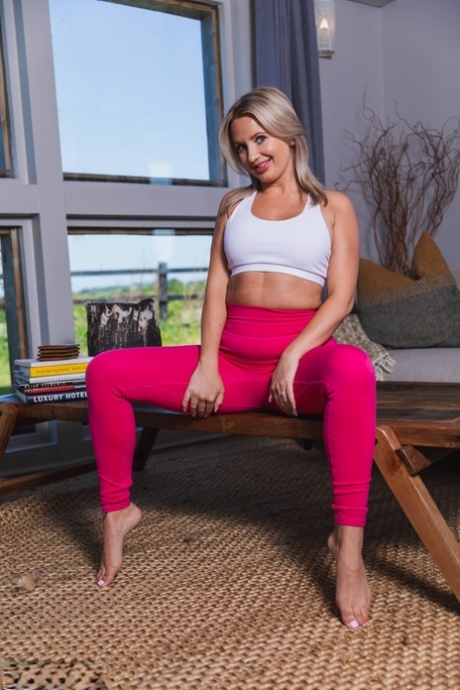 Blondes britisches Mädchen Gina Barrett geht oben ohne und zieht rosa Leggings aus