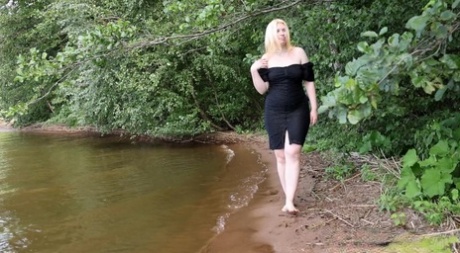 Blondes Mädchen Magnolia steht beim Pissen im Wasser