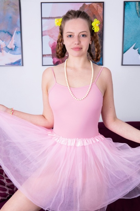 Jonge ballerina Sissy legt haar grote lichaam vrij van kleding op een sofa