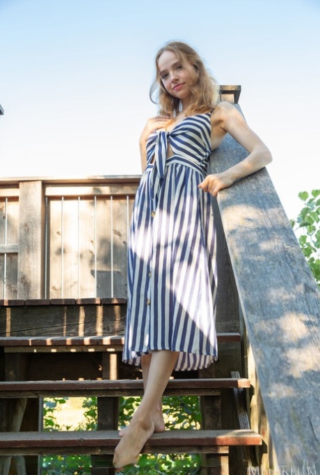 Mooie blonde tiener Rinna Ly glijdt uit haar jurk om naakt op de trap van het dek te gaan