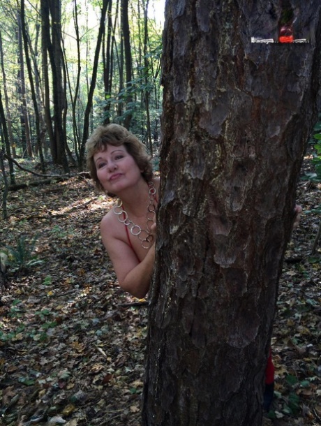 Eldre dame Busty Bliss blir helt naken mens hun er i en skog