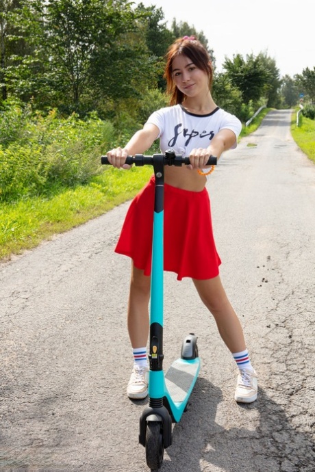 Söta tonåringen Aura är naken i strumpor och sneakers när hon åker scooter