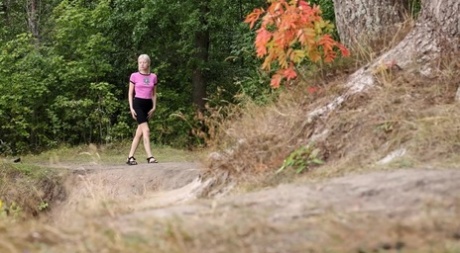 Blond meisje Vasya toont haar haarloze kutje terwijl ze pist op het platteland