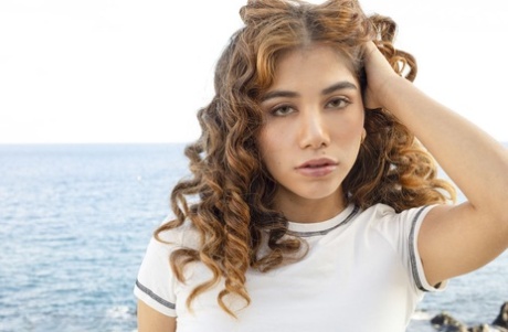 Latina Teen Marina Gold spielt mit ihrem lockigen Haar, bevor sie sich auszieht