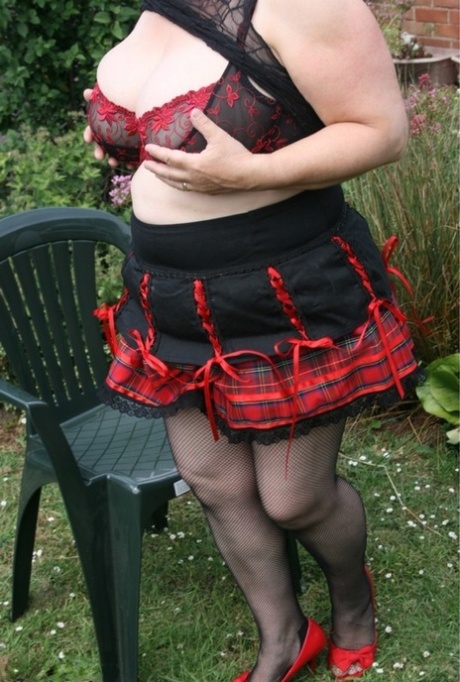 La rellenita británica Kinky Carol muestra sus grandes tetas antes de una acción al aire libre en minifalda