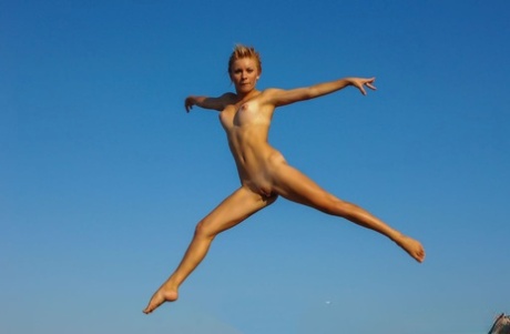 A adolescente nua Tienette O mostra a sua flexibilidade durante uma ida à praia