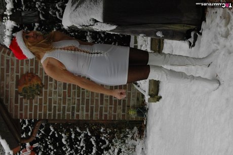 Äldre blondin Kyras Nylons leker i snön innan hon blir modell för underkläder på julafton