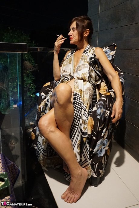 Dojrzała brunetka Diana Ananta pociera gołe stopy podczas palenia
