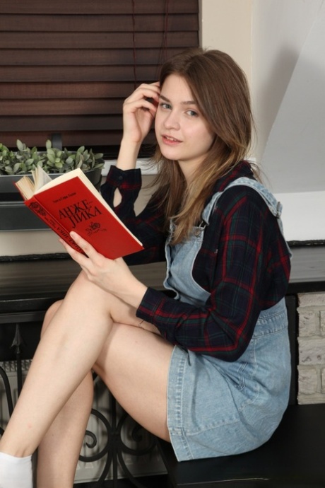 Pěkná teenagerka Minni Love čte knihu v tvrdých deskách, než se úplně svlékne