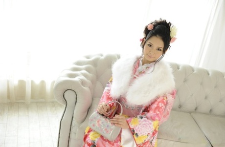 Japanese beauty Ako Nishino works free of traditional clothing on a couch