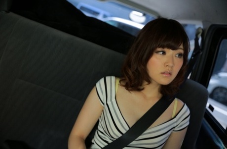 Японская девушка Томока Сакурай играет со своей подстриженной киской в автомобиле