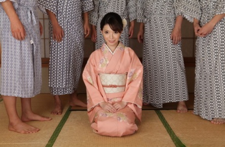 La ragazza giapponese Hikaru Kirishima viene parzialmente sollevata dal kimono dagli uomini
