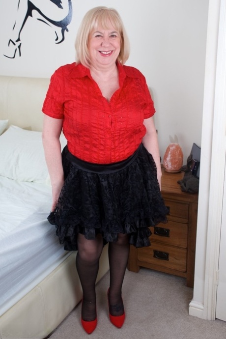 Speedy Bee, une grosse femme britannique plus âgée, se déshabille sur un lit avec ses sous-vêtements et ses bas.