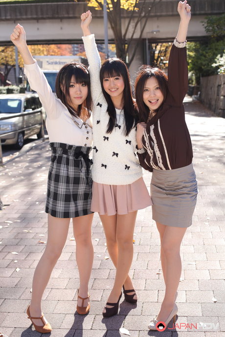 Drie Japanse meisjes in rokjes poseren buiten voor een SFW-shoot