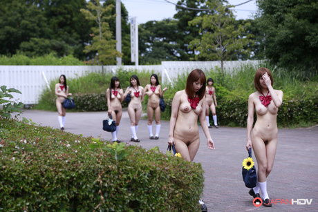 En gruppe japanske jenter poserer nakne på et jorde i hvite sokker.