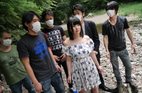 Cute Japanese girl Tsuna Kimura gives a bunch of boys oral sex on rocky ground