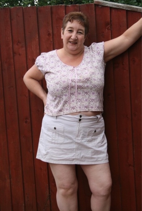 Overweight mature British woman Kinky Carol strips to her lingerie in a yard