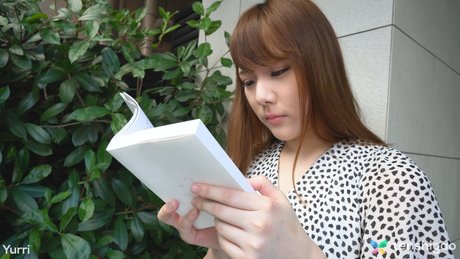 Japans Tiener Yuri leest een boek voor het hebben van seks boven op een bed
