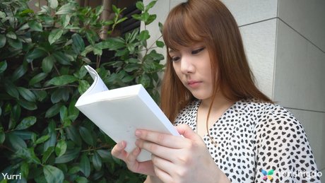 Japanese teen Yuri reads a book before having sex atop a bed