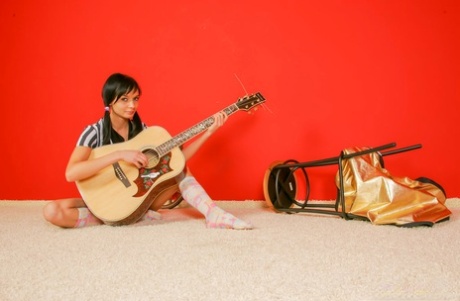 Donker haired tiener Fulla K plays an acoustic guitar before going nude in socks