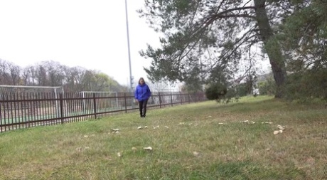 Blank meisje Naomi Benet neemt een broodnodige pis op het gras in het openbaar