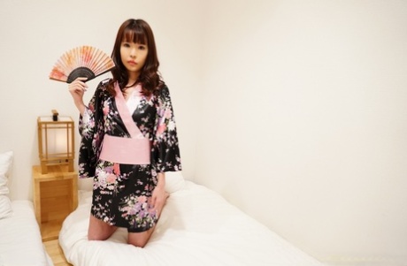 Japanese teen Aya holds an Oriental fan before taking off her kimono